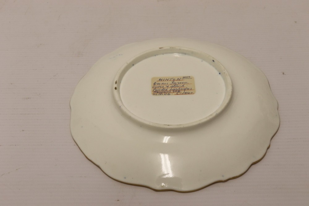 A 19th-century Mintons porcelain dessert cream tureen with lid and handles positioned alongside its matching stand, decorated with cobalt blue ground, gold gilding, and hand-painted landscape scenes. View VII
