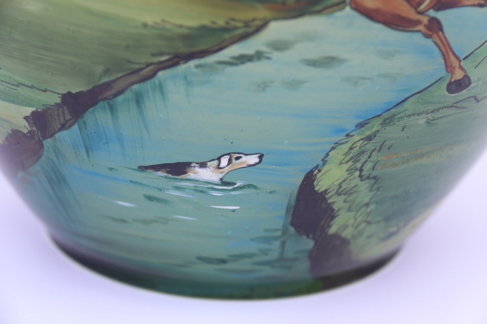A bulbous green hand-blown glass vase featuring a hand-painted enamel scene of fox hunters riding horses across a landscape. View VII
