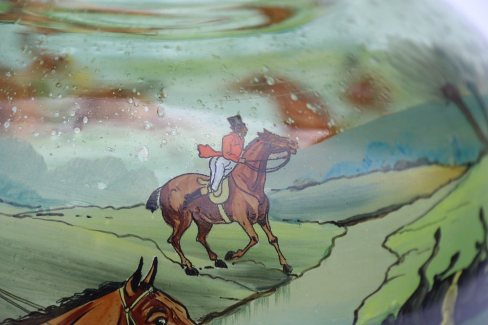 A bulbous green hand-blown glass vase featuring a hand-painted enamel scene of fox hunters riding horses across a landscape. View VIII