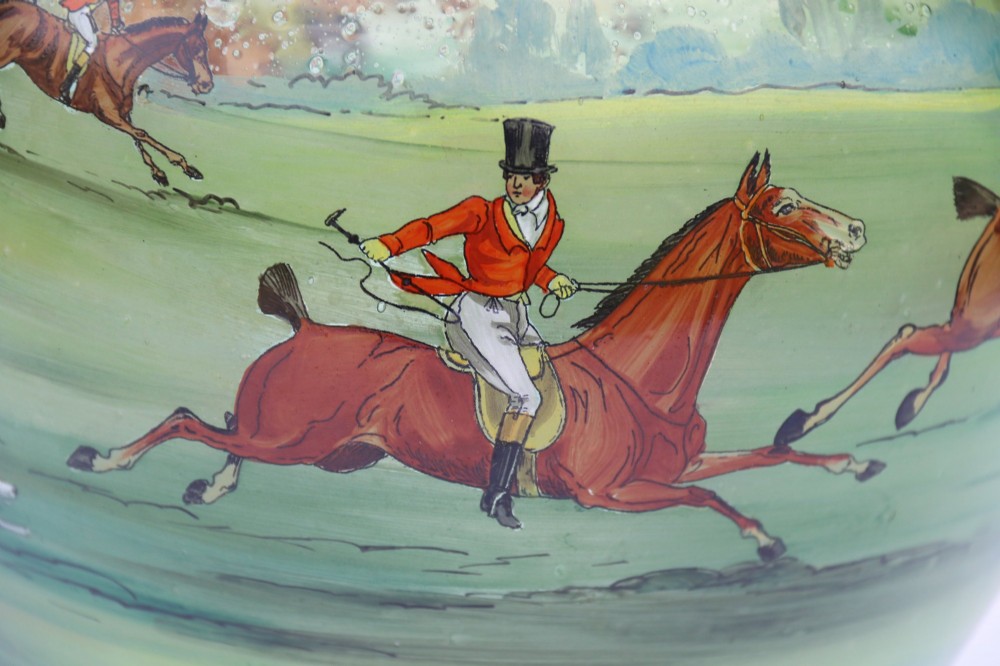 A bulbous green hand-blown glass vase featuring a hand-painted enamel scene of fox hunters riding horses across a landscape. View XII