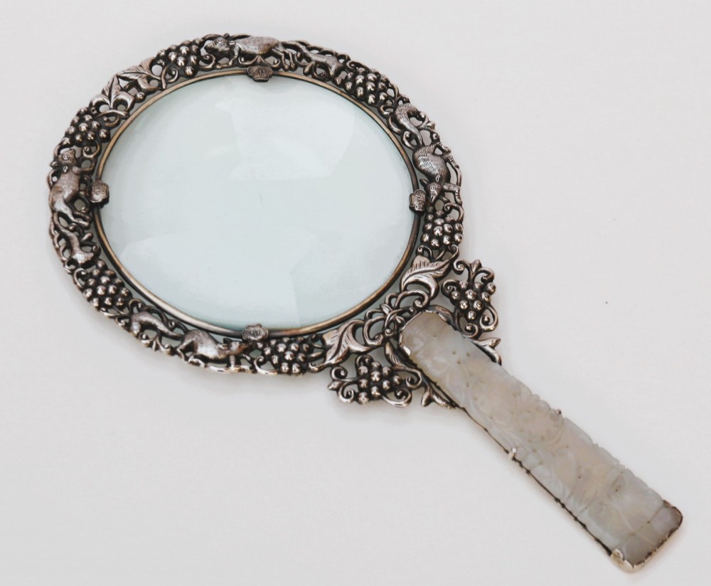 A late 19th-century Chinese silver magnifying glass featuring a carved white jade handle and an openwork grapevine frame with animal details. View IV