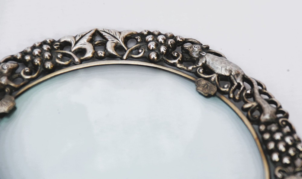 A late 19th-century Chinese silver magnifying glass featuring a carved white jade handle and an openwork grapevine frame with animal details. View XIII