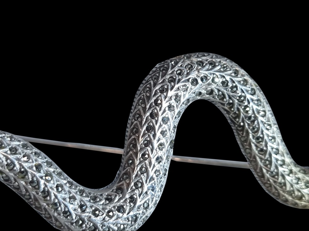 An Art Deco sterling silver brooch formed in the shape of an undulating snake, encrusted with pave-set marcasite stones and detailed with red stone eyes. View IV