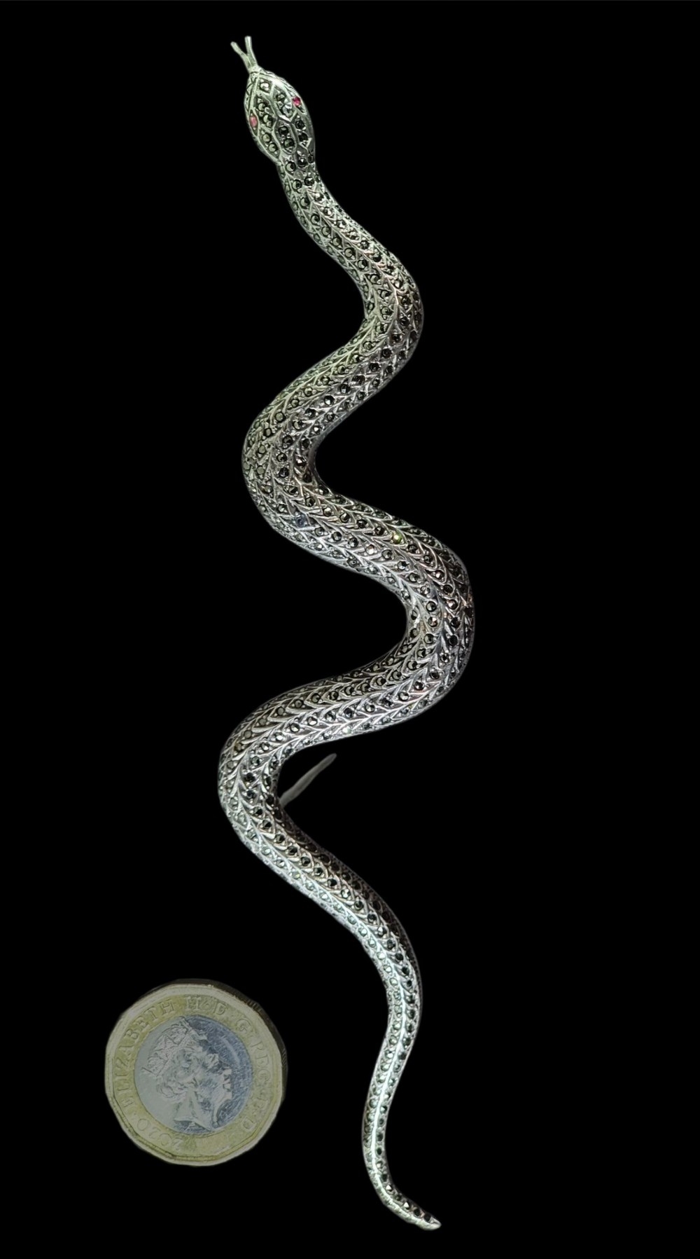 An Art Deco sterling silver brooch formed in the shape of an undulating snake, encrusted with pave-set marcasite stones and detailed with red stone eyes. View V
