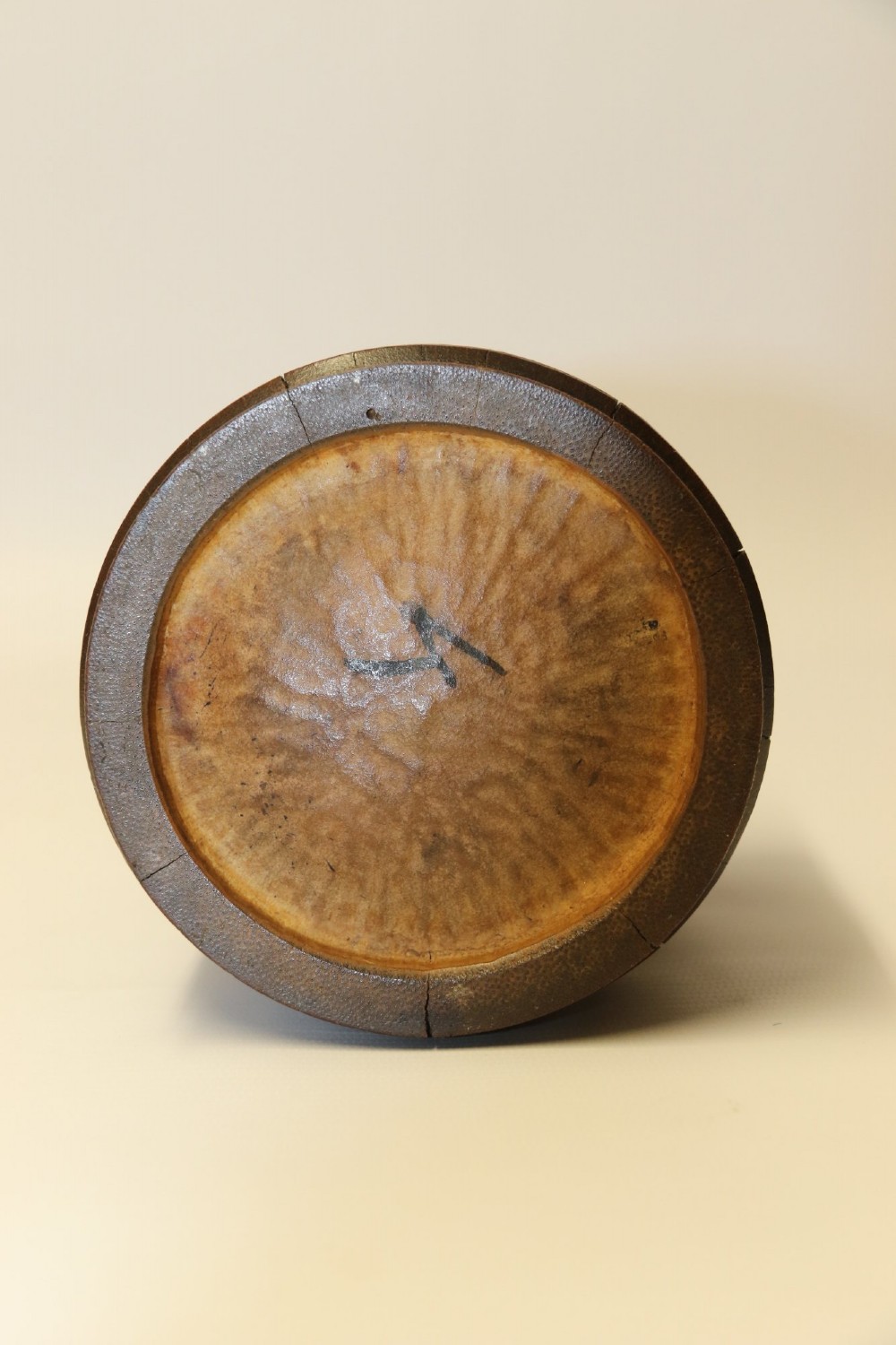 A cylindrical dark brown bamboo tea caddy featuring intricate high-relief carvings of Chinese figures, trees, and architecture with a metal escutcheon. View IX