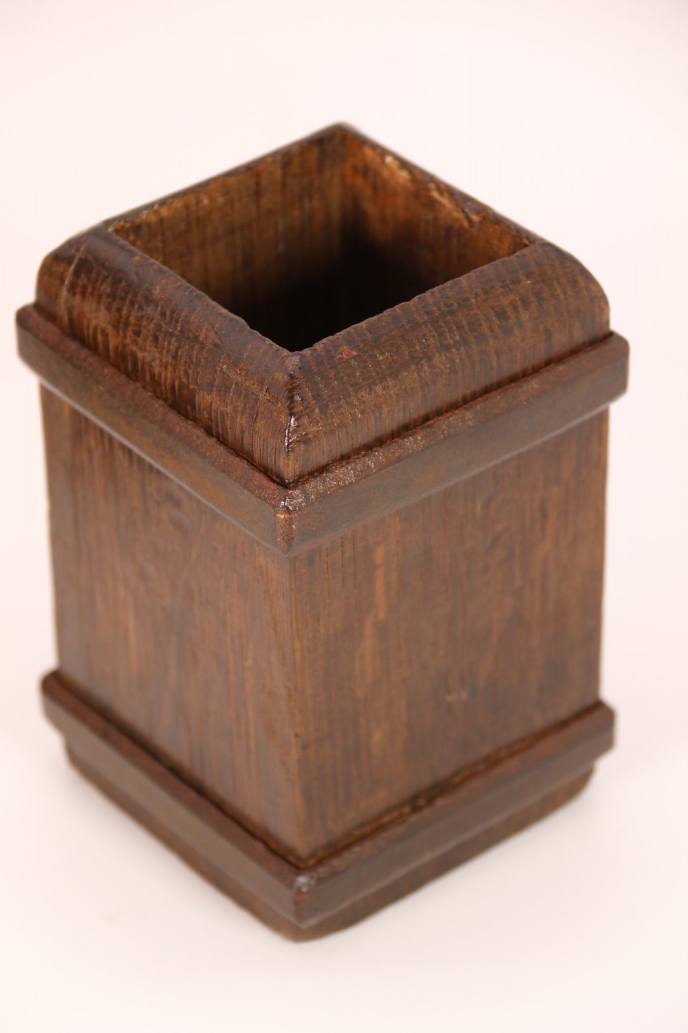 An antique dark oak apothecary crusher set consisting of a square wooden vessel with iron mounts alongside a matching rectangular wooden plunger with a shaped handle. View V