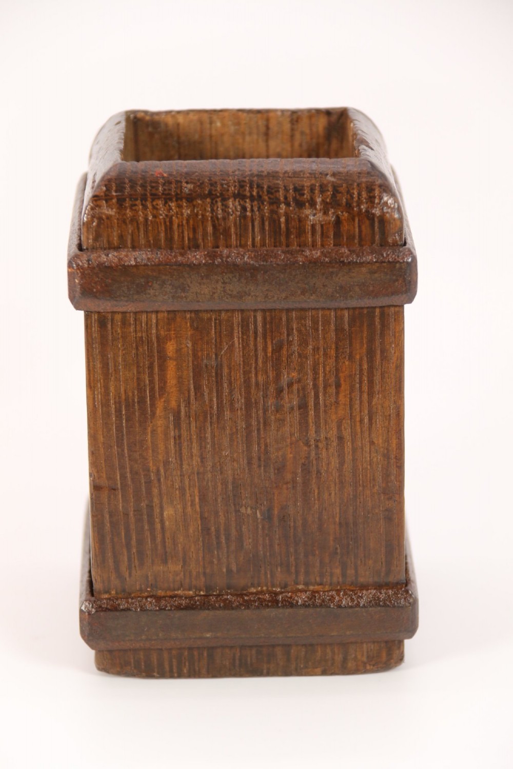 An antique dark oak apothecary crusher set consisting of a square wooden vessel with iron mounts alongside a matching rectangular wooden plunger with a shaped handle. View VI