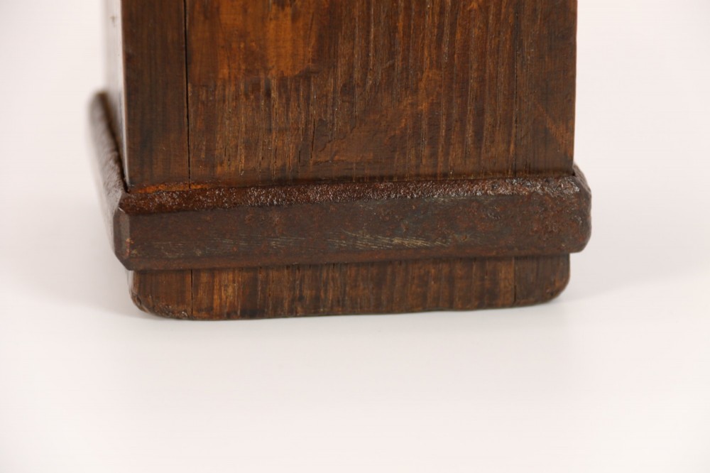 An antique dark oak apothecary crusher set consisting of a square wooden vessel with iron mounts alongside a matching rectangular wooden plunger with a shaped handle. View VIII