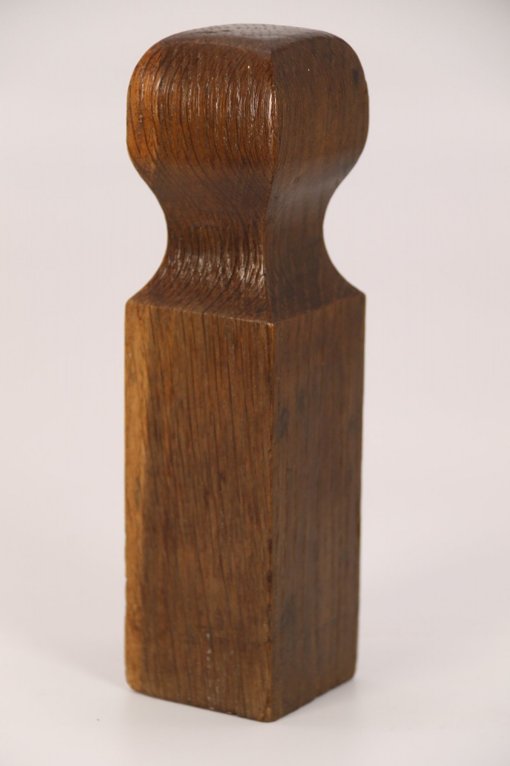 An antique dark oak apothecary crusher set consisting of a square wooden vessel with iron mounts alongside a matching rectangular wooden plunger with a shaped handle. View X
