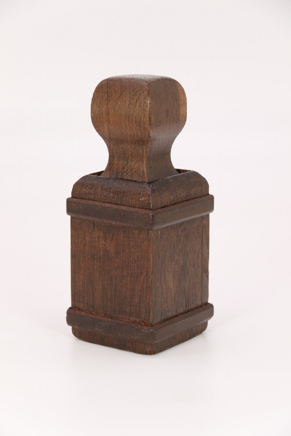 An antique dark oak apothecary crusher set consisting of a square wooden vessel with iron mounts alongside a matching rectangular wooden plunger with a shaped handle. View XI