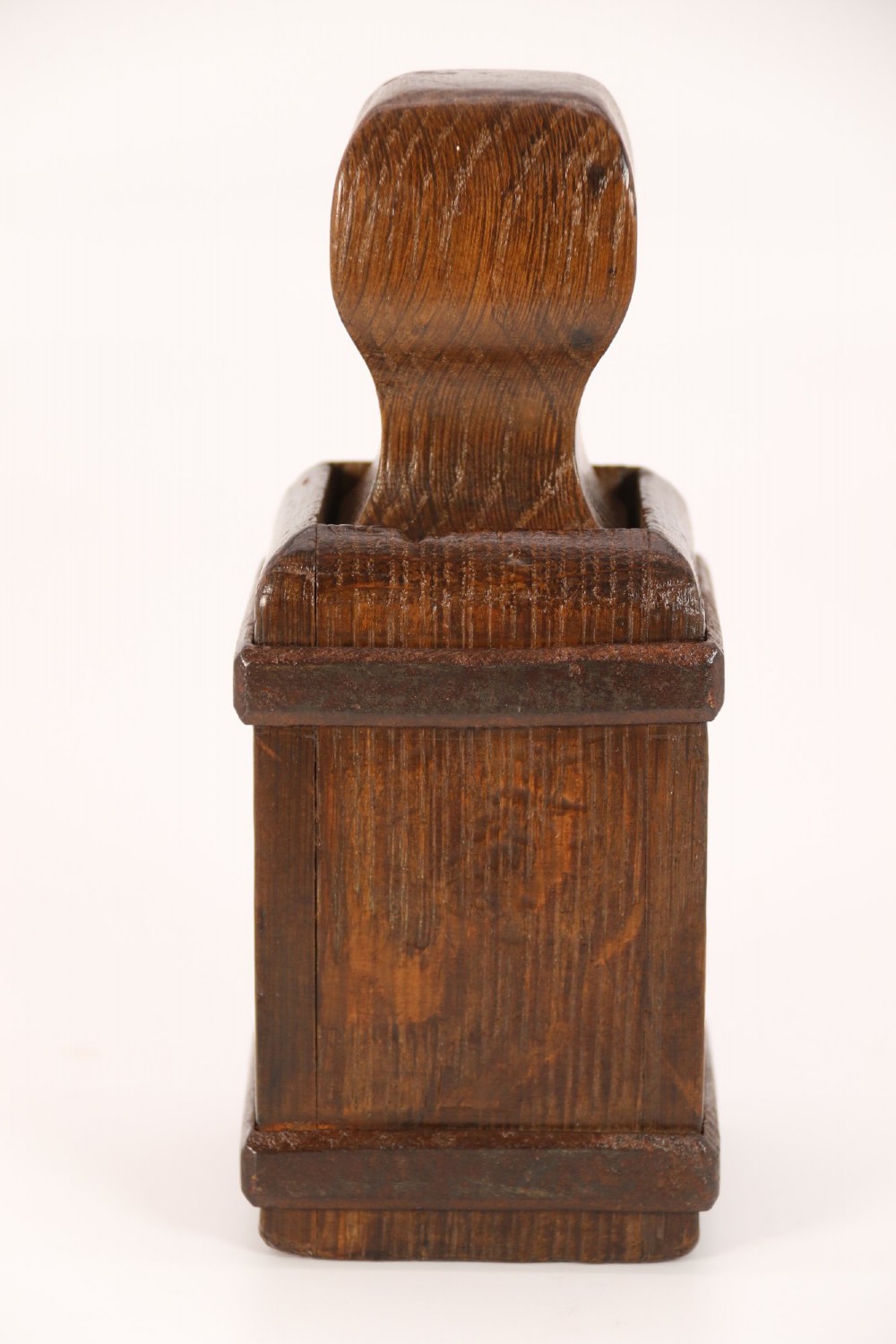 An antique dark oak apothecary crusher set consisting of a square wooden vessel with iron mounts alongside a matching rectangular wooden plunger with a shaped handle. View XIV