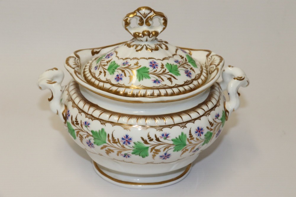 A white Regency Spode felspar porcelain covered sucrier featuring hand-painted green leaves, blue cornflowers, twin scrolled handles, and gilded embellishments. View II