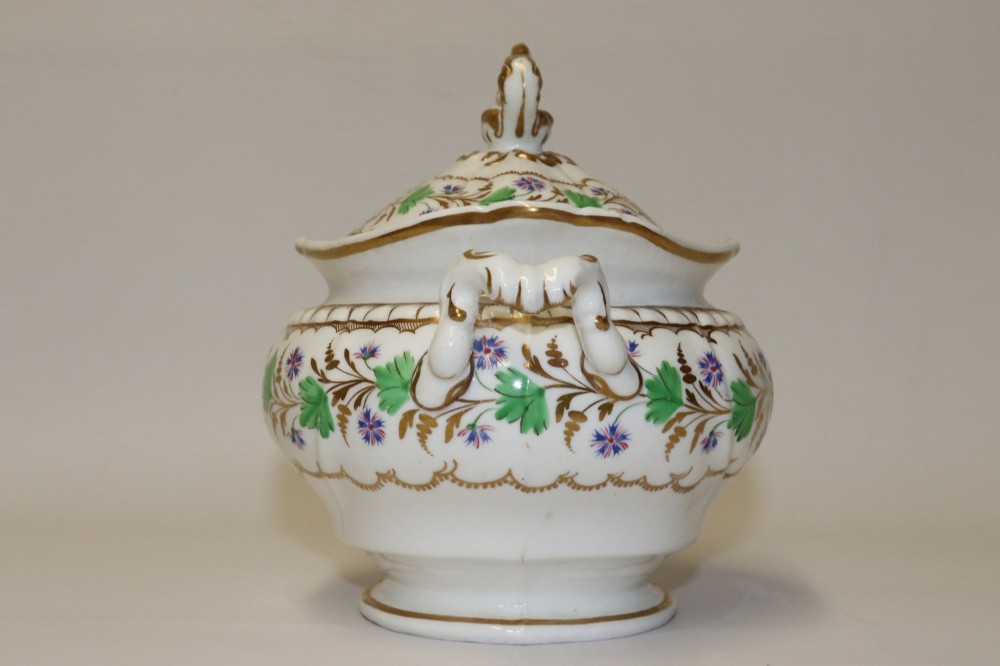 A white Regency Spode felspar porcelain covered sucrier featuring hand-painted green leaves, blue cornflowers, twin scrolled handles, and gilded embellishments. View V