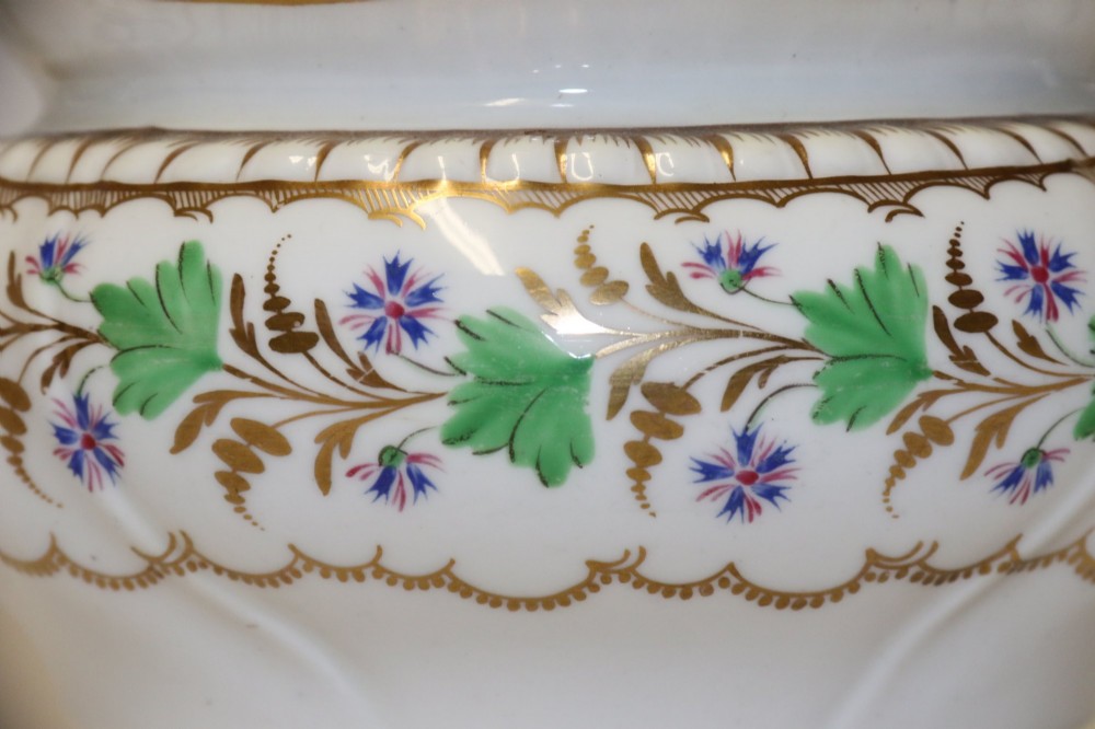 A white Regency Spode felspar porcelain covered sucrier featuring hand-painted green leaves, blue cornflowers, twin scrolled handles, and gilded embellishments. View VII