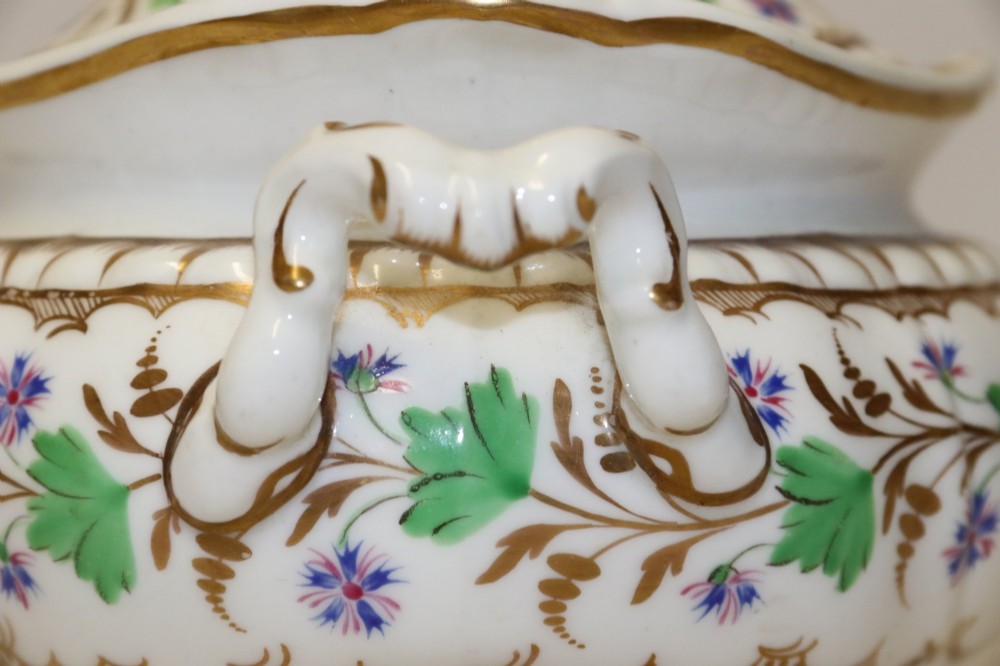A white Regency Spode felspar porcelain covered sucrier featuring hand-painted green leaves, blue cornflowers, twin scrolled handles, and gilded embellishments. View IX
