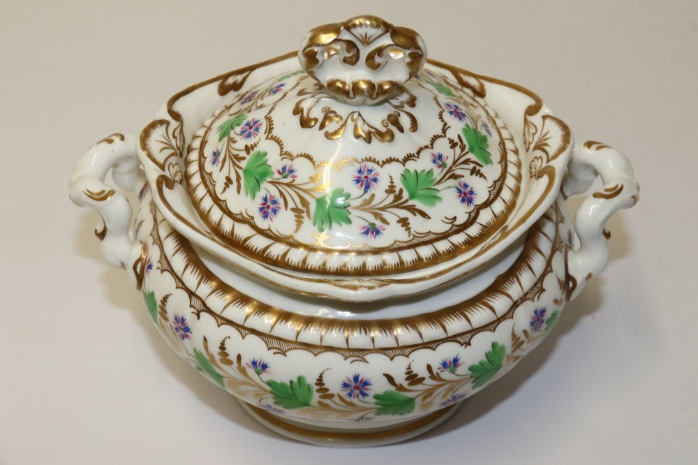 A white Regency Spode felspar porcelain covered sucrier featuring hand-painted green leaves, blue cornflowers, twin scrolled handles, and gilded embellishments. View X