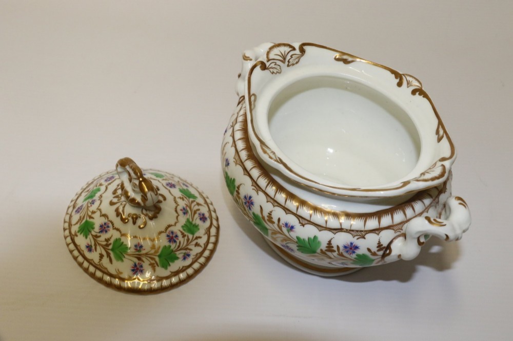 A white Regency Spode felspar porcelain covered sucrier featuring hand-painted green leaves, blue cornflowers, twin scrolled handles, and gilded embellishments. View XI