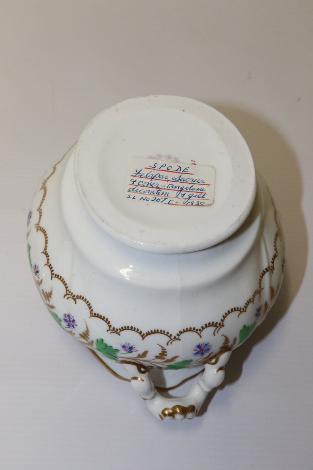 A white Regency Spode felspar porcelain covered sucrier featuring hand-painted green leaves, blue cornflowers, twin scrolled handles, and gilded embellishments. View XII
