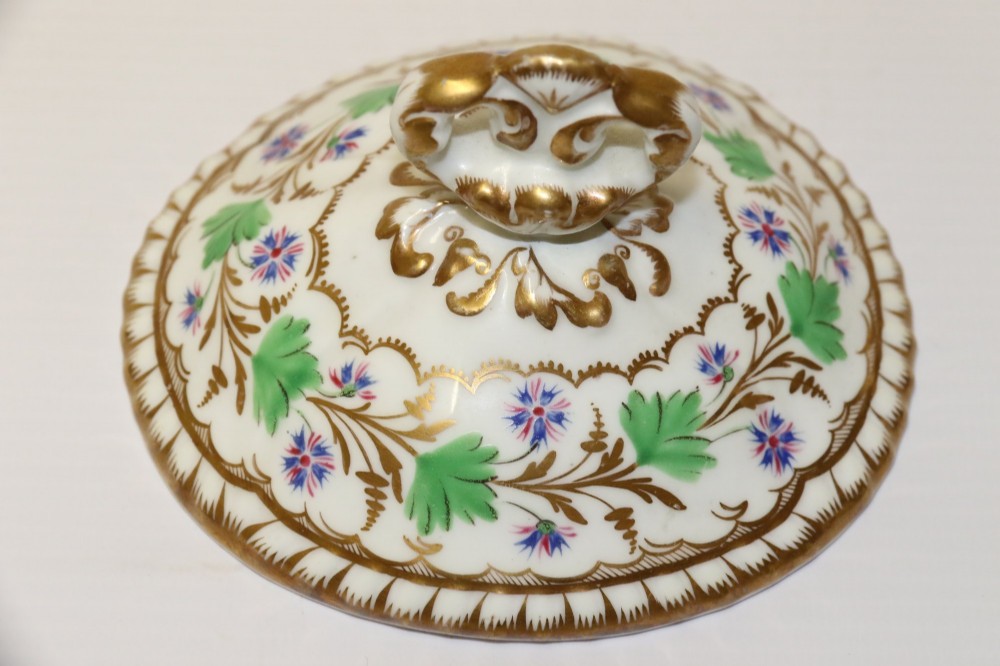 A white Regency Spode felspar porcelain covered sucrier featuring hand-painted green leaves, blue cornflowers, twin scrolled handles, and gilded embellishments. View XV