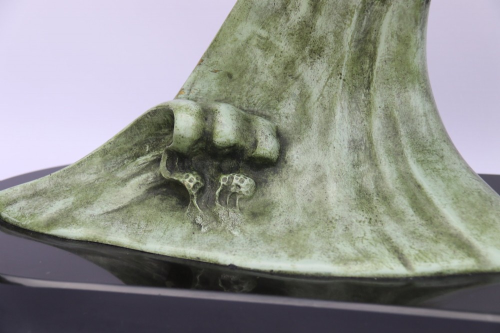 A patinated green bronze sculpture depicting an albatross with extended wings skimming a crested wave, mounted on an oval black marble plinth. View III