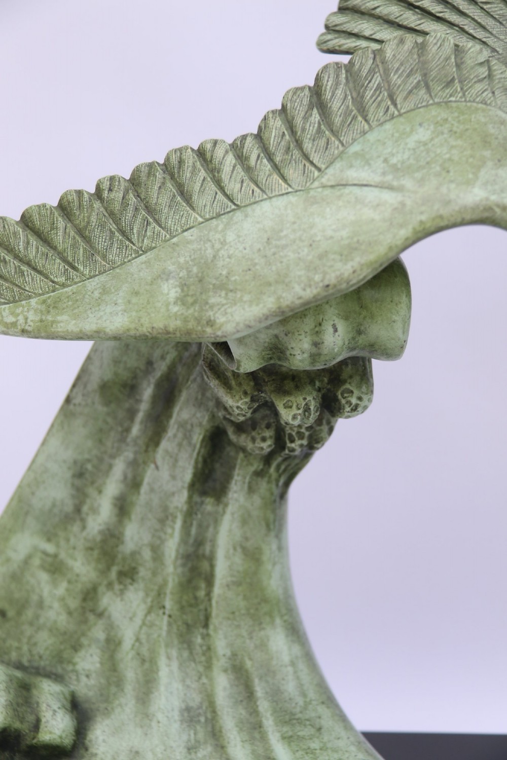 A patinated green bronze sculpture depicting an albatross with extended wings skimming a crested wave, mounted on an oval black marble plinth. View IV