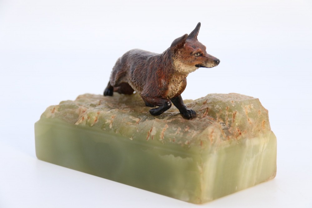 A cold-painted bronze sculpture of a fox in motion, mounted upon a rectangular carved green onyx base. View III