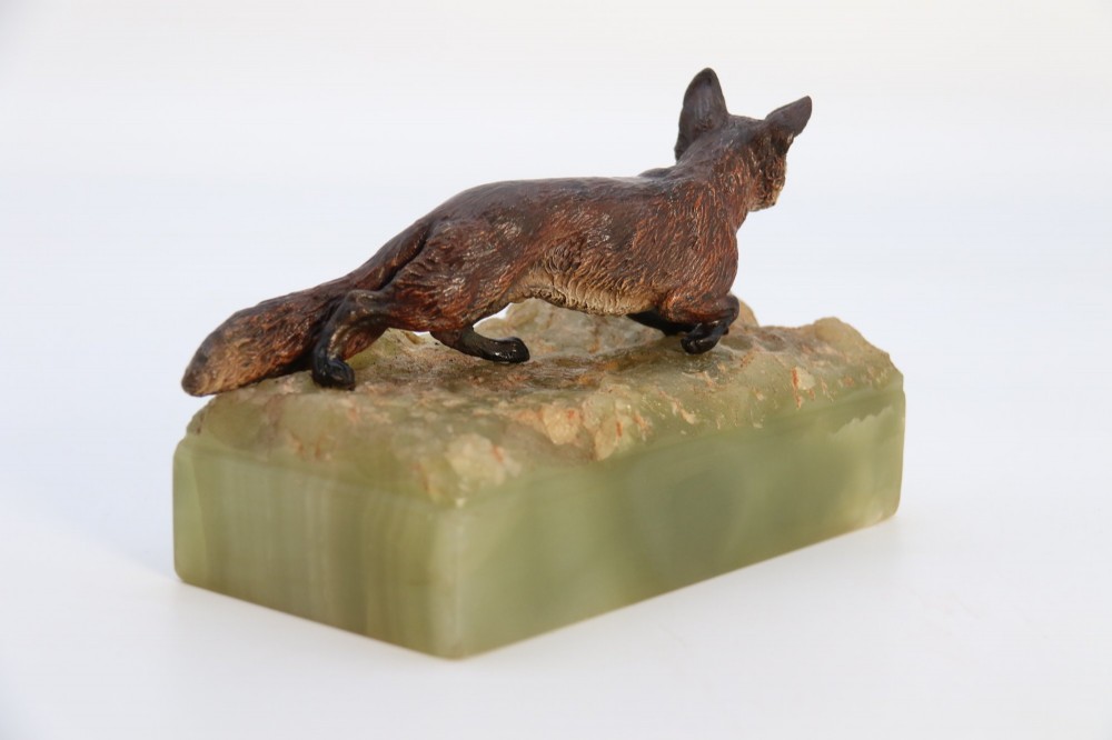 A cold-painted bronze sculpture of a fox in motion, mounted upon a rectangular carved green onyx base. View V