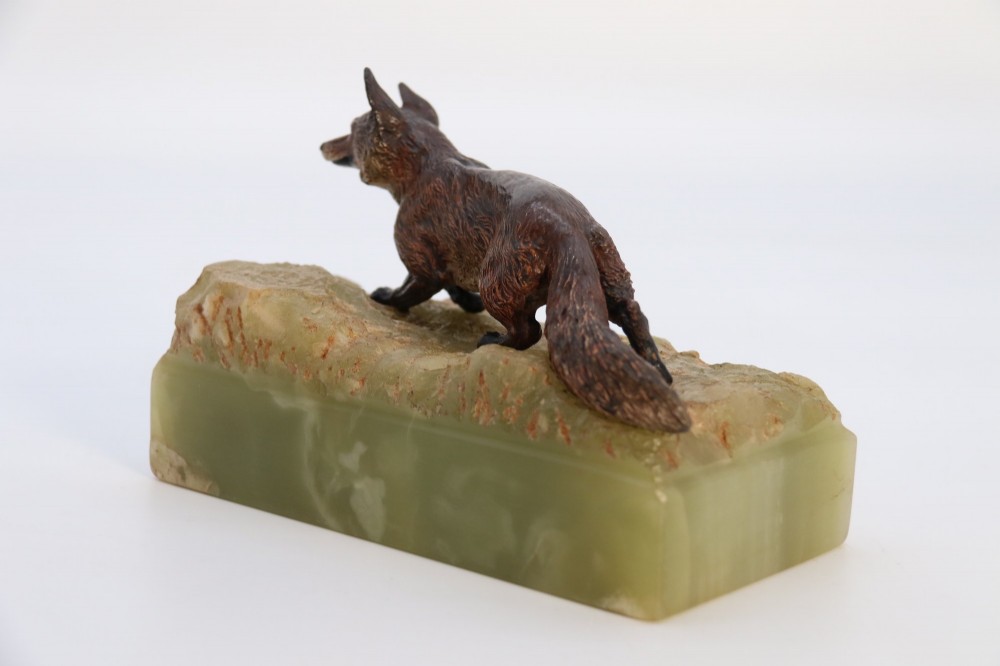 A cold-painted bronze sculpture of a fox in motion, mounted upon a rectangular carved green onyx base. View VII