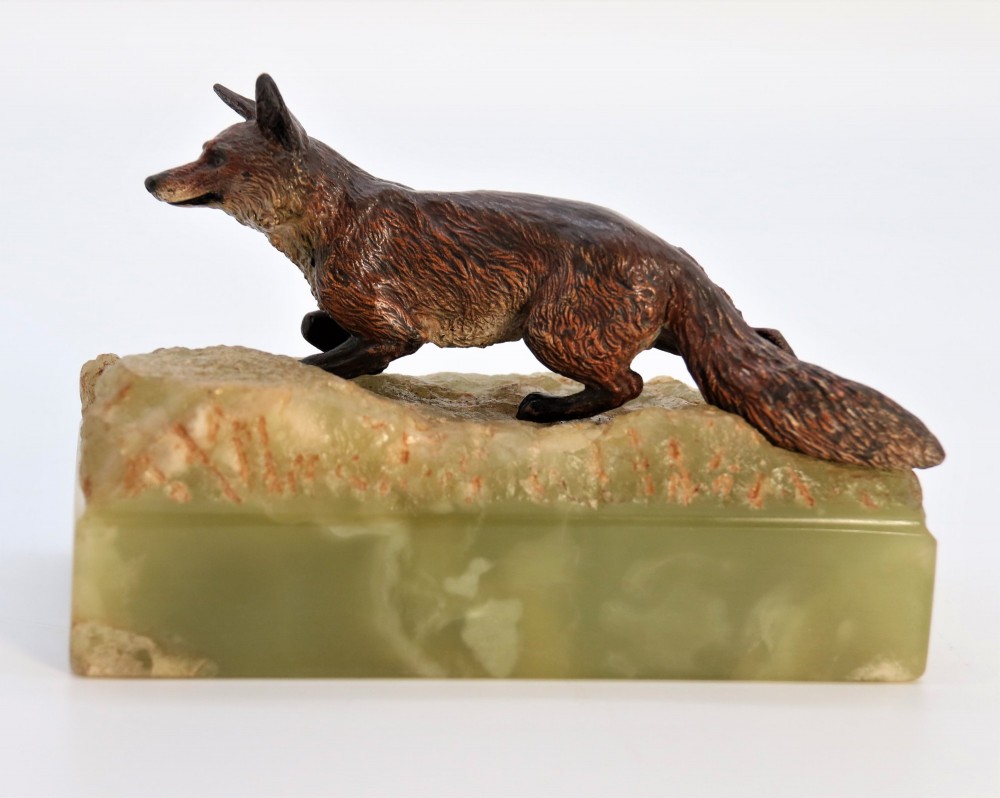 A cold-painted bronze sculpture of a fox in motion, mounted upon a rectangular carved green onyx base. View VIII