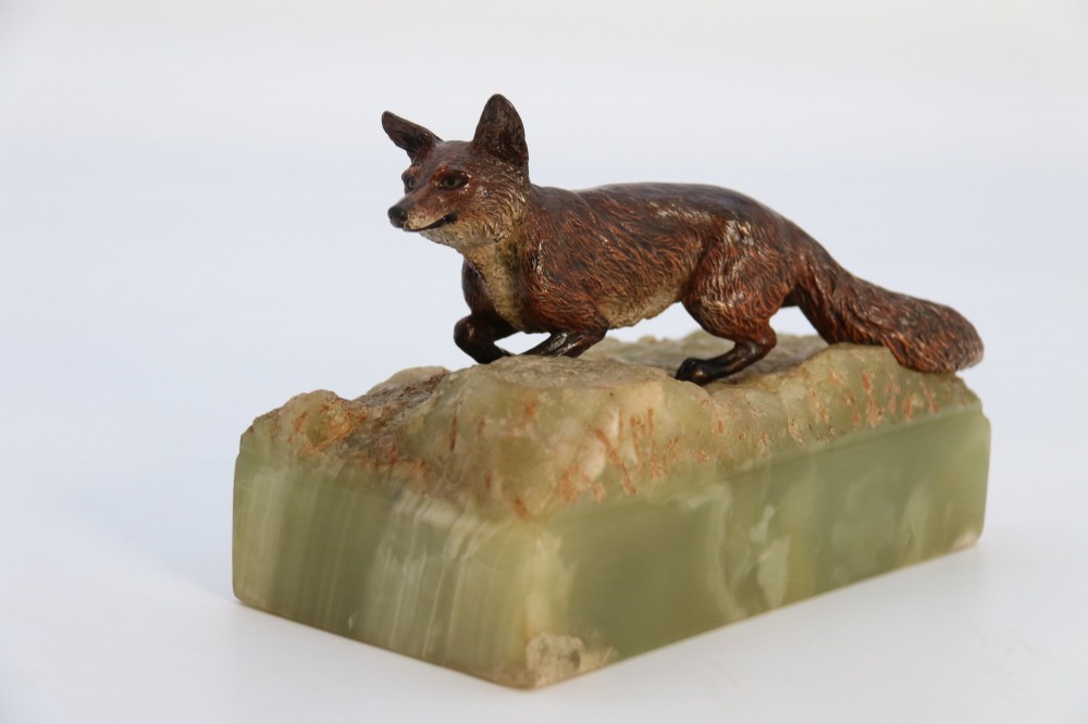 A cold-painted bronze sculpture of a fox in motion, mounted upon a rectangular carved green onyx base. View X