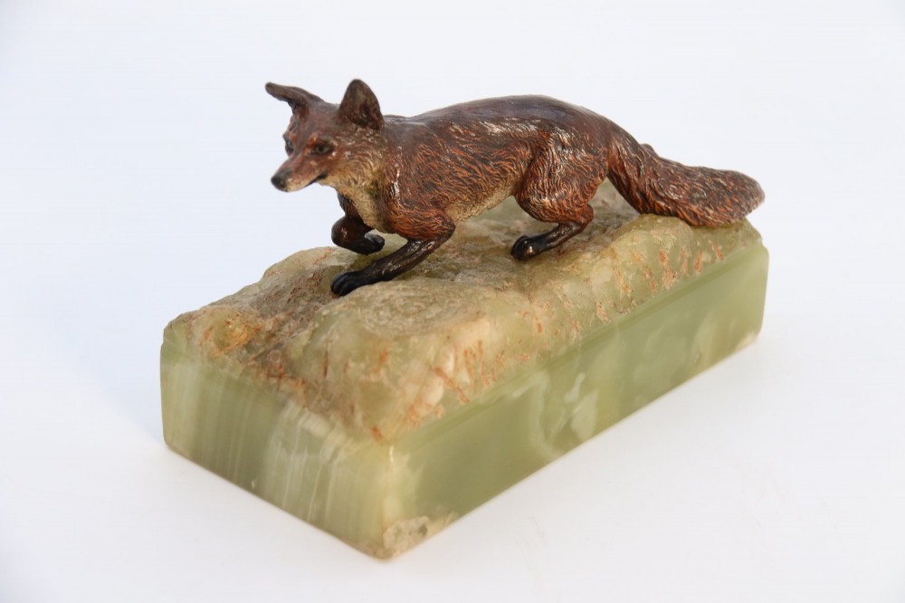 A cold-painted bronze sculpture of a fox in motion, mounted upon a rectangular carved green onyx base. View XI