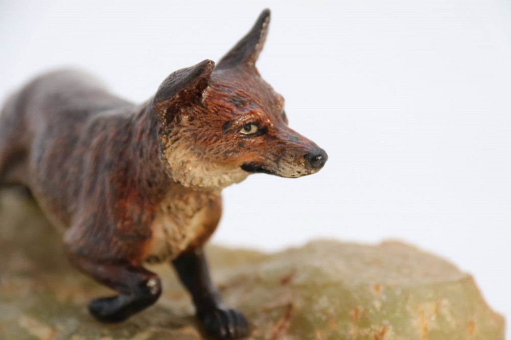 A cold-painted bronze sculpture of a fox in motion, mounted upon a rectangular carved green onyx base. View XII