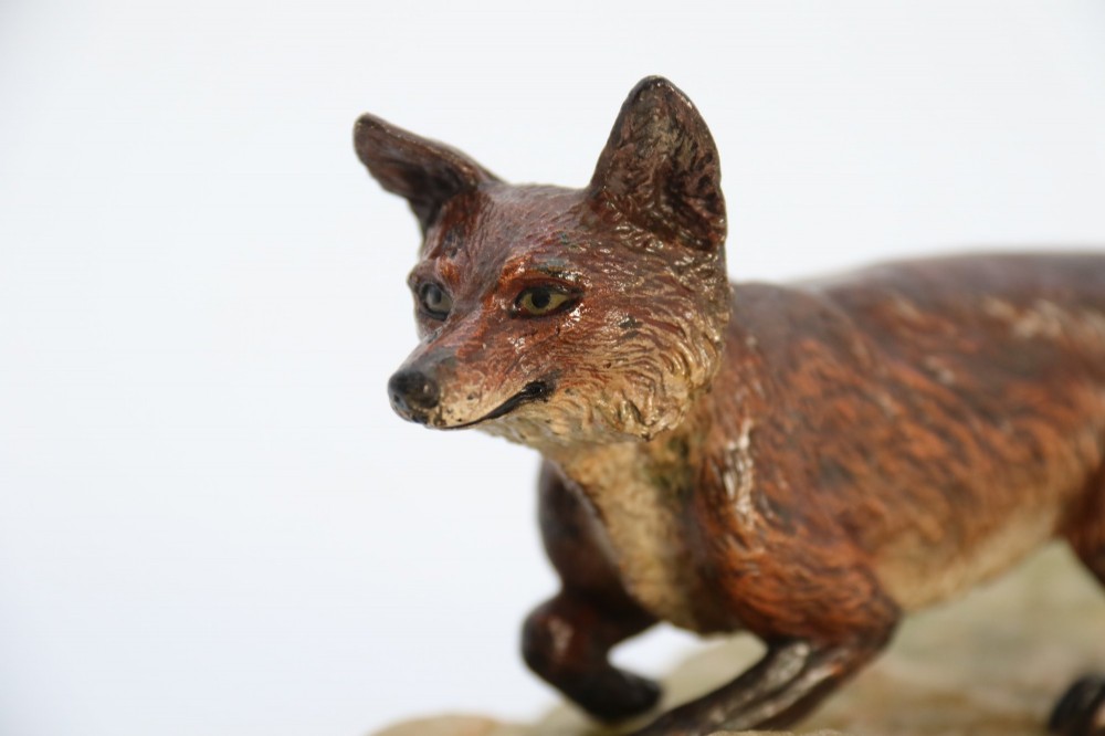 A cold-painted bronze sculpture of a fox in motion, mounted upon a rectangular carved green onyx base. View XIII