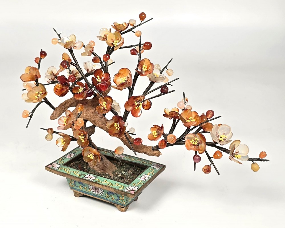 A Chinese decorative bonsai tree featuring carved amber-coloured hardstone plum blossoms on wired branches set inside a turquoise floral cloisonne planter. View II