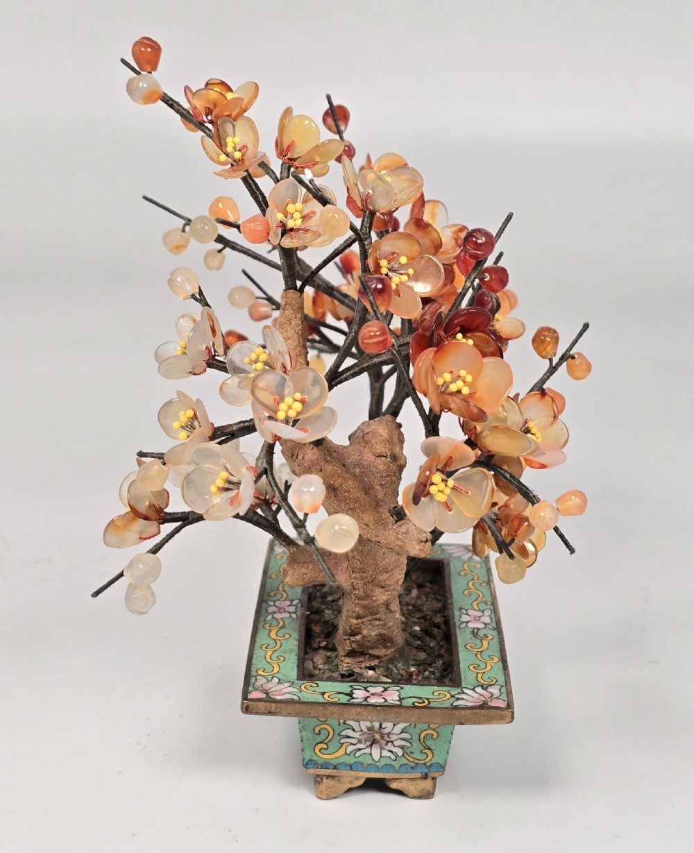 A Chinese decorative bonsai tree featuring carved amber-coloured hardstone plum blossoms on wired branches set inside a turquoise floral cloisonne planter. View III