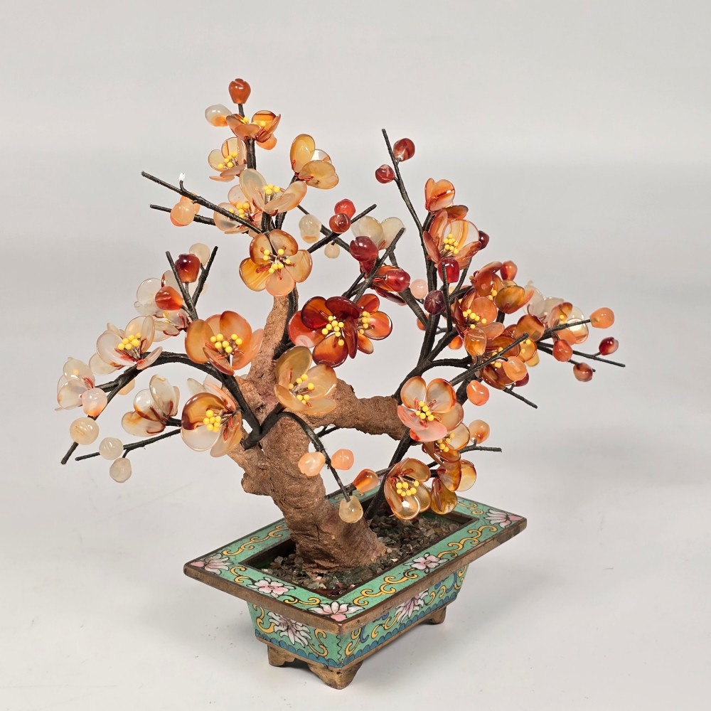 A Chinese decorative bonsai tree featuring carved amber-coloured hardstone plum blossoms on wired branches set inside a turquoise floral cloisonne planter. View IV