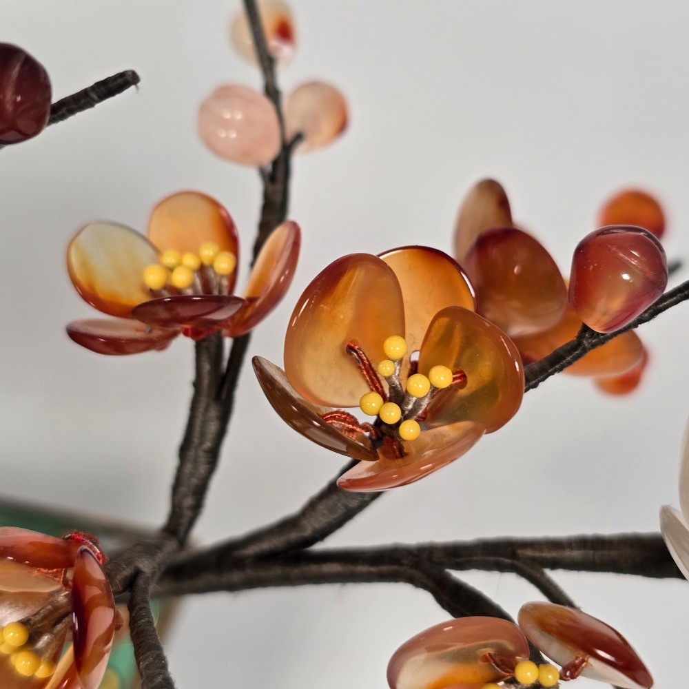 A Chinese decorative bonsai tree featuring carved amber-coloured hardstone plum blossoms on wired branches set inside a turquoise floral cloisonne planter. View VII