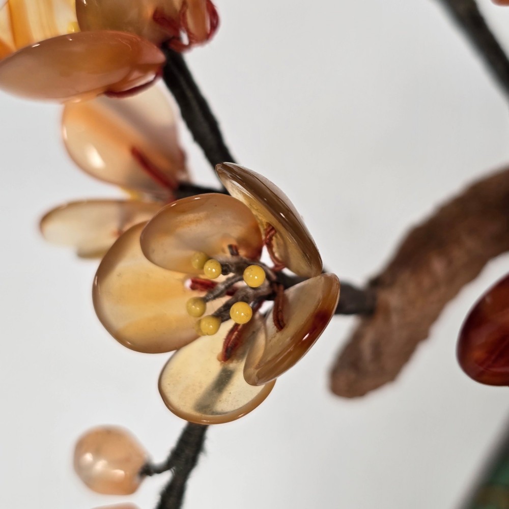 A Chinese decorative bonsai tree featuring carved amber-coloured hardstone plum blossoms on wired branches set inside a turquoise floral cloisonne planter. View VIII