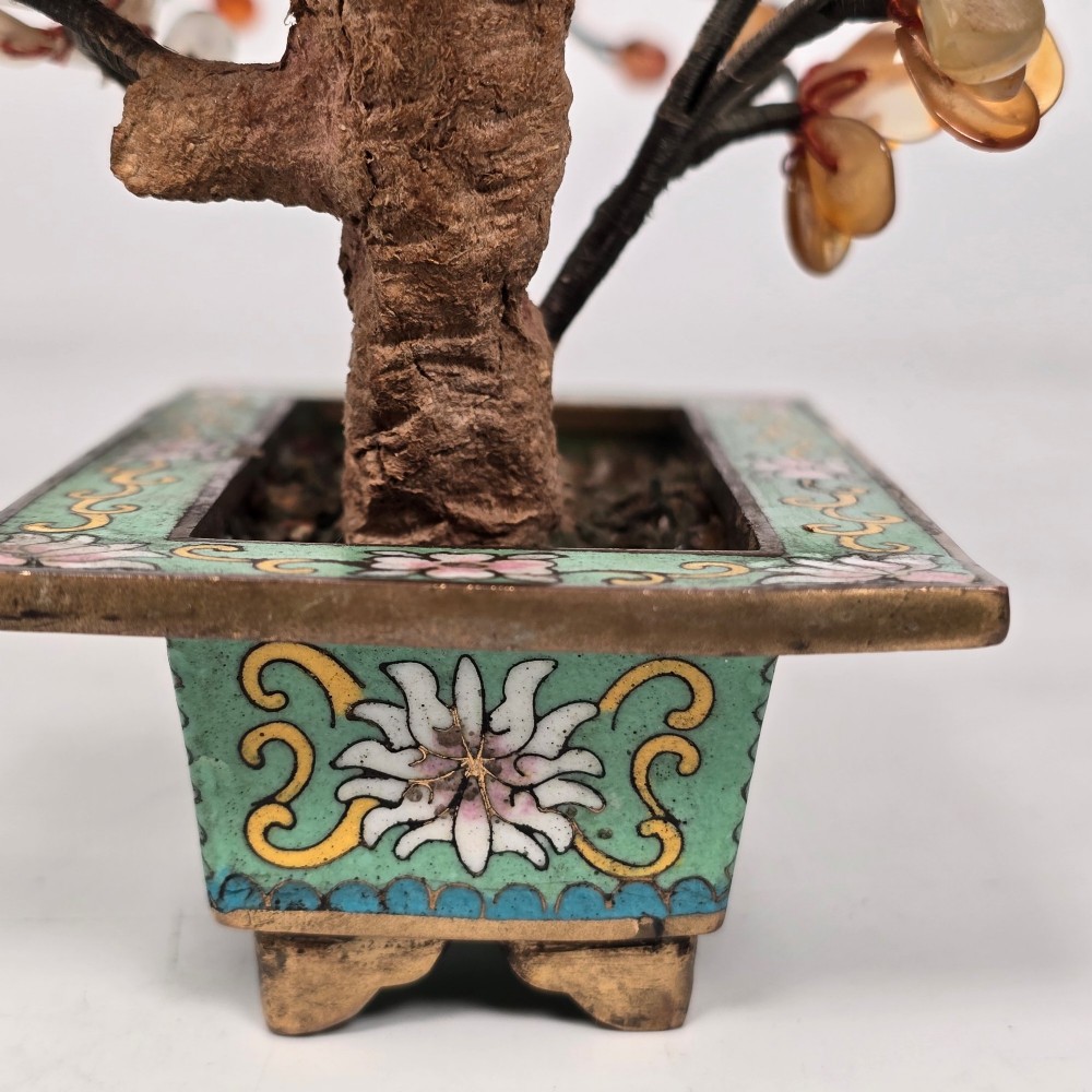 A Chinese decorative bonsai tree featuring carved amber-coloured hardstone plum blossoms on wired branches set inside a turquoise floral cloisonne planter. View XII