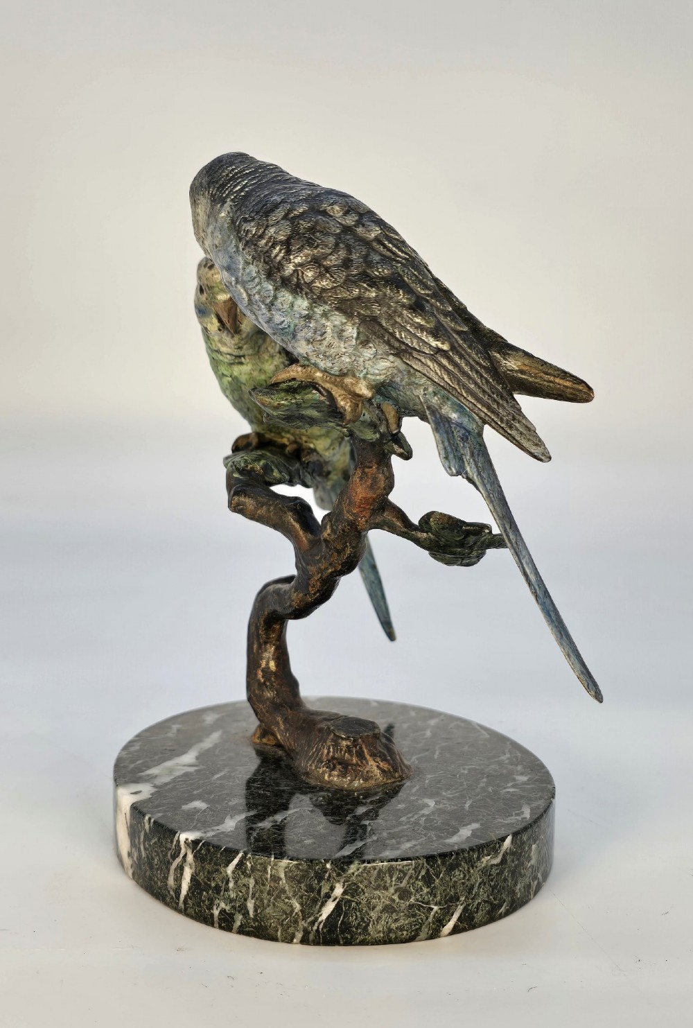 A cold-painted bronze sculpture featuring two budgerigars perched on a branch mounted upon a round green marble base. View IV