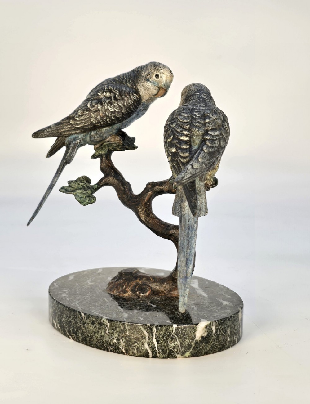 A cold-painted bronze sculpture featuring two budgerigars perched on a branch mounted upon a round green marble base. View VII