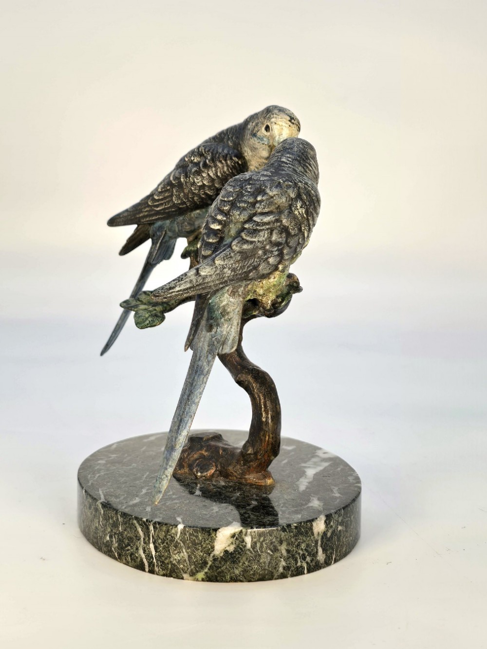 A cold-painted bronze sculpture featuring two budgerigars perched on a branch mounted upon a round green marble base. View VIII