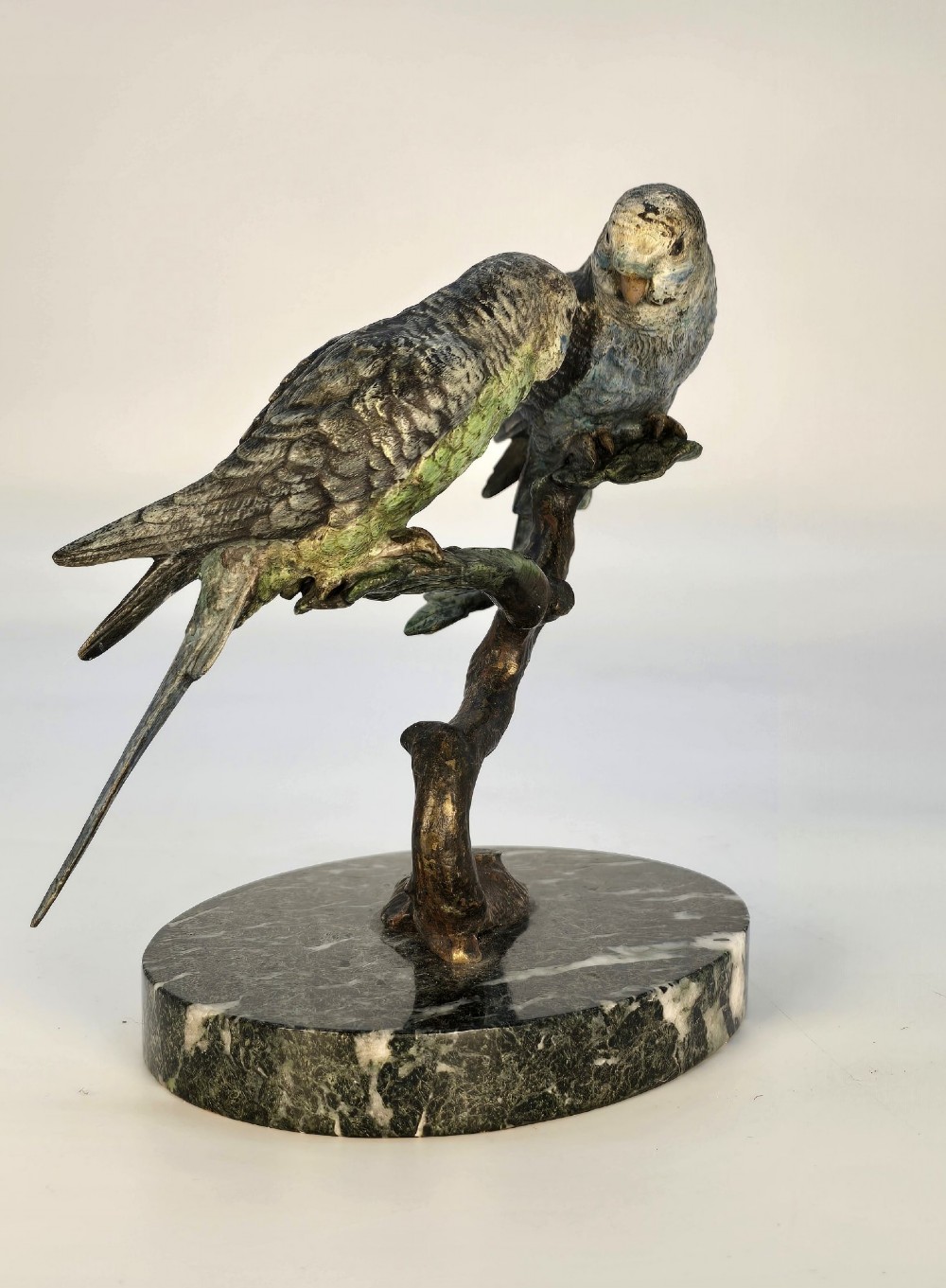 A cold-painted bronze sculpture featuring two budgerigars perched on a branch mounted upon a round green marble base. View IX