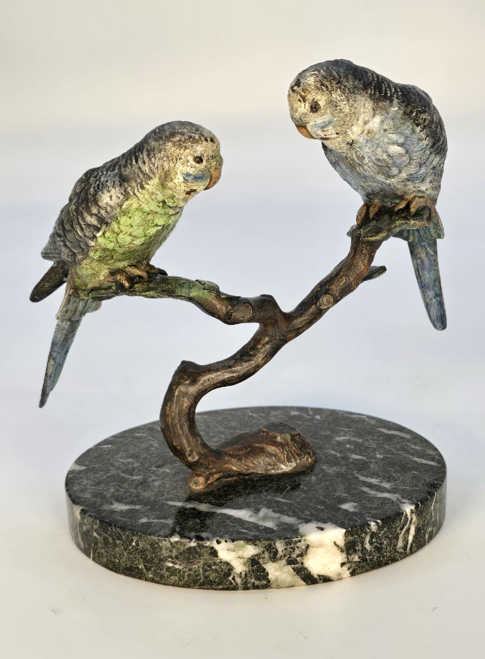 A cold-painted bronze sculpture featuring two budgerigars perched on a branch mounted upon a round green marble base. View XII
