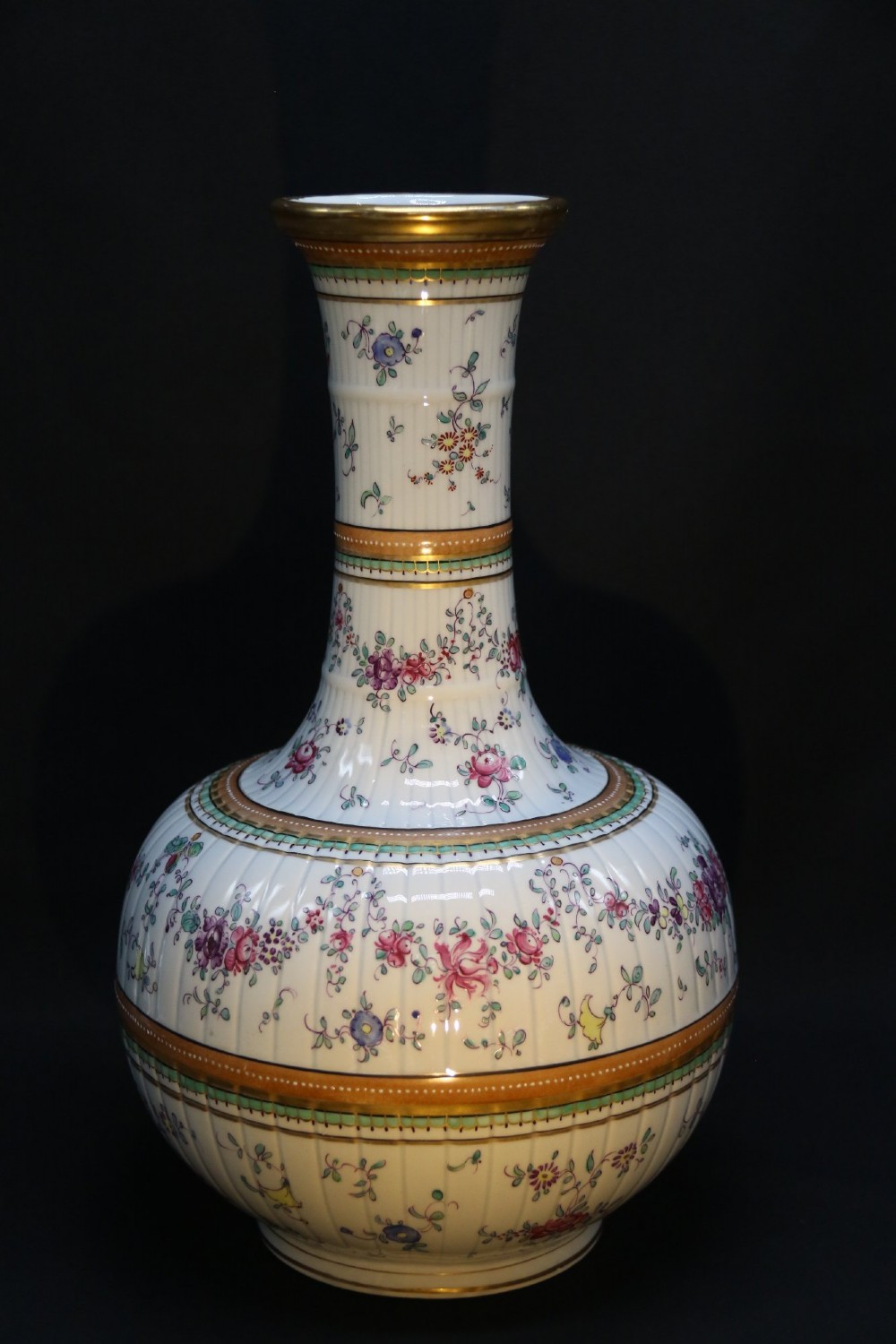 A bulbous hand-painted white porcelain vase with vertical fluting, decorated with floral sprigs and gold gilded borders. View II