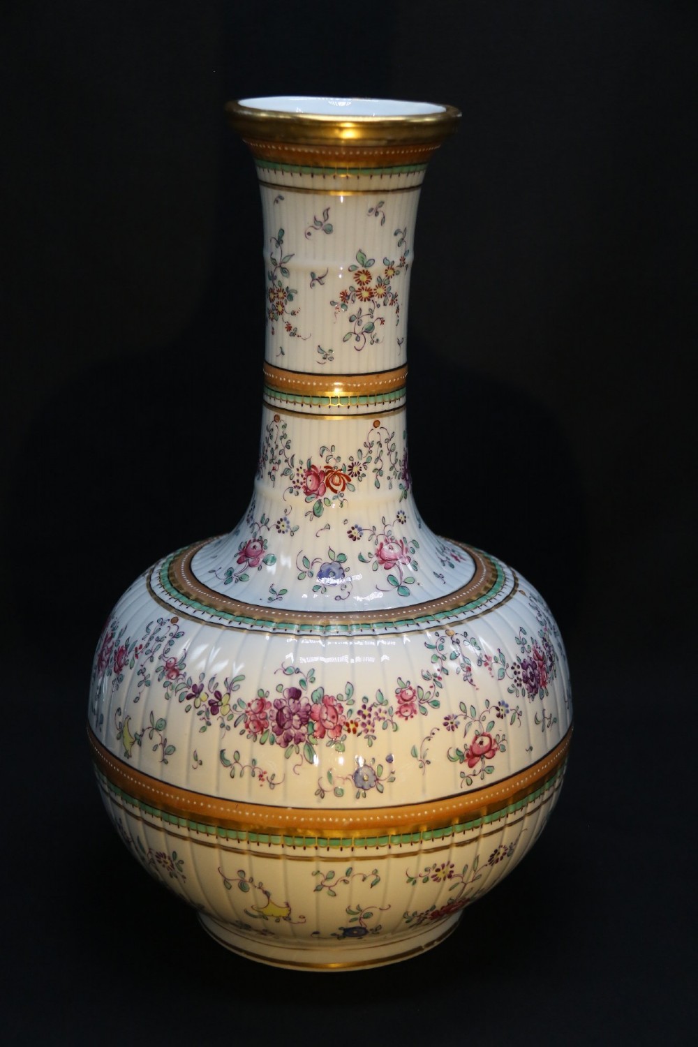 A bulbous hand-painted white porcelain vase with vertical fluting, decorated with floral sprigs and gold gilded borders. View IV