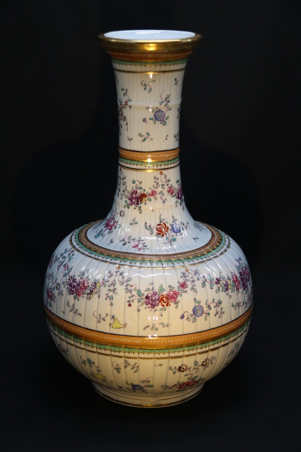 A bulbous hand-painted white porcelain vase with vertical fluting, decorated with floral sprigs and gold gilded borders. View VI