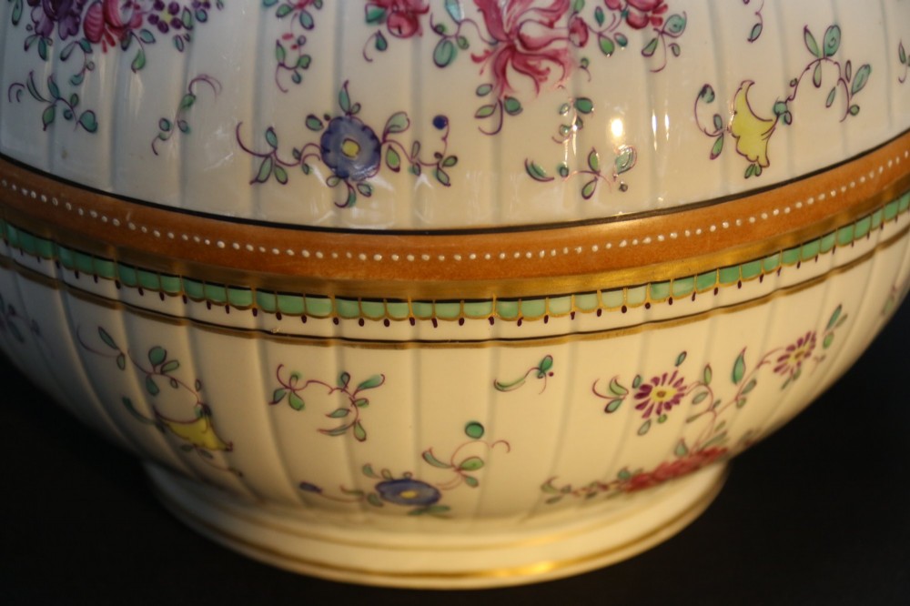 A bulbous hand-painted white porcelain vase with vertical fluting, decorated with floral sprigs and gold gilded borders. View X