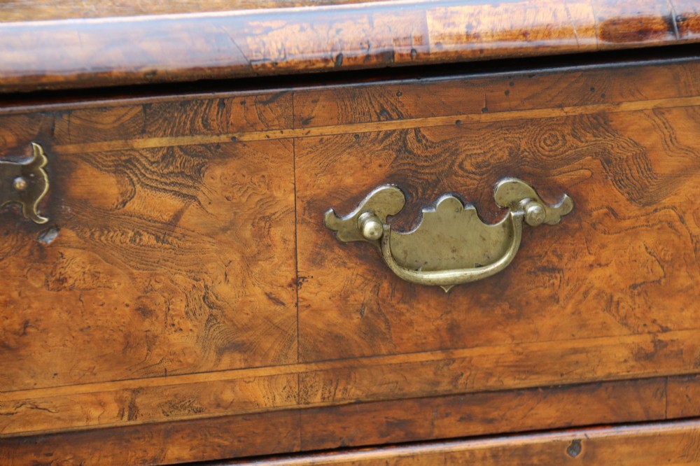 A George II burr elm lowboy featuring three drawers, brass drop handles, a scalloped apron, and cabriole legs terminating in pad feet. View IV