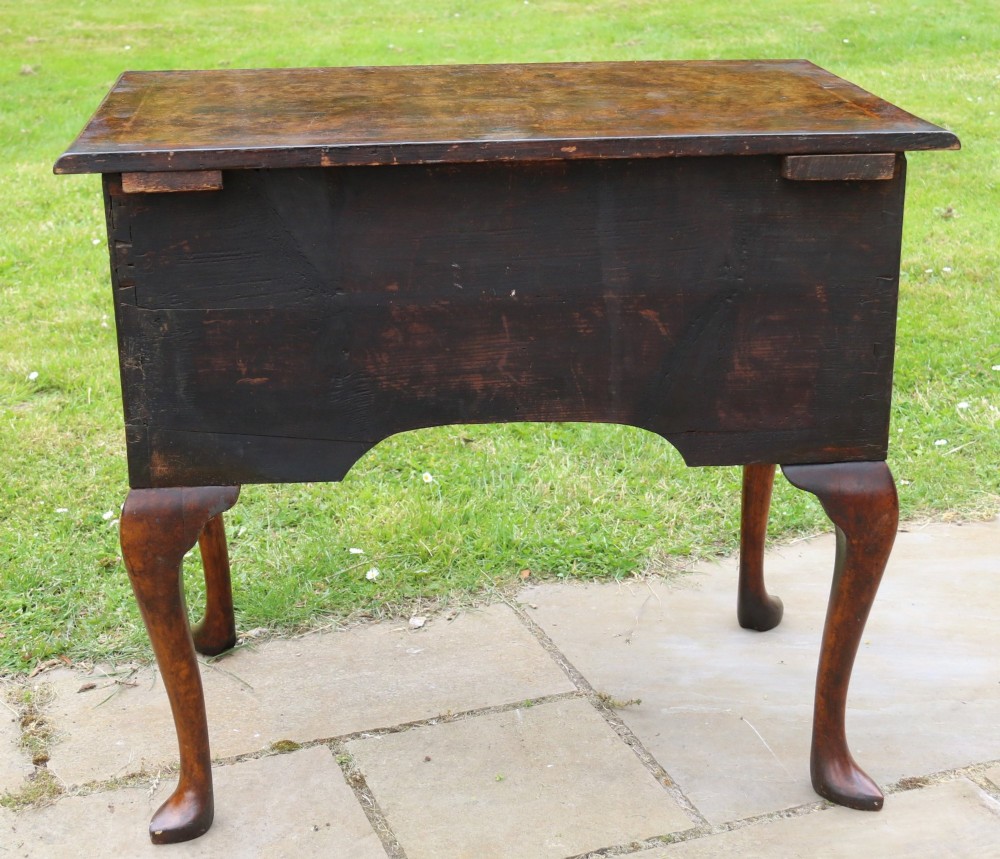 A George II burr elm lowboy featuring three drawers, brass drop handles, a scalloped apron, and cabriole legs terminating in pad feet. View VIII